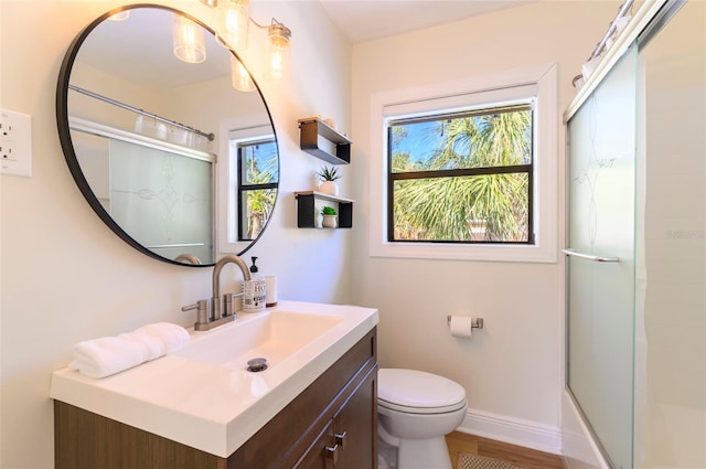 full bathroom featuring vanity, a wealth of natural light, combined bath / shower with glass door, and toilet