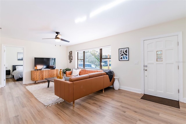 living room with light hardwood / wood-style floors and ceiling fan