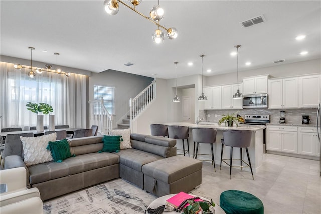 living room with sink and an inviting chandelier