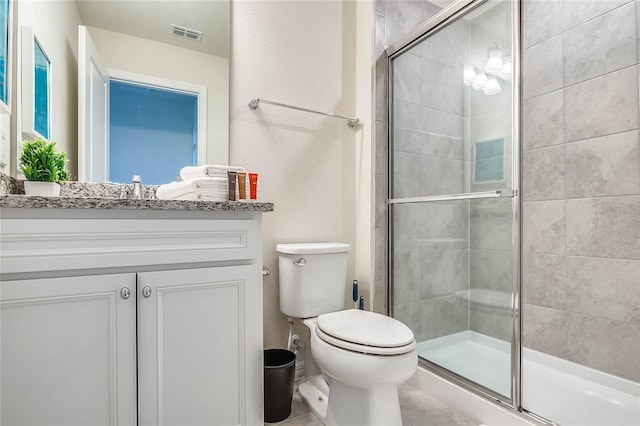 bathroom featuring a shower with door, vanity, and toilet