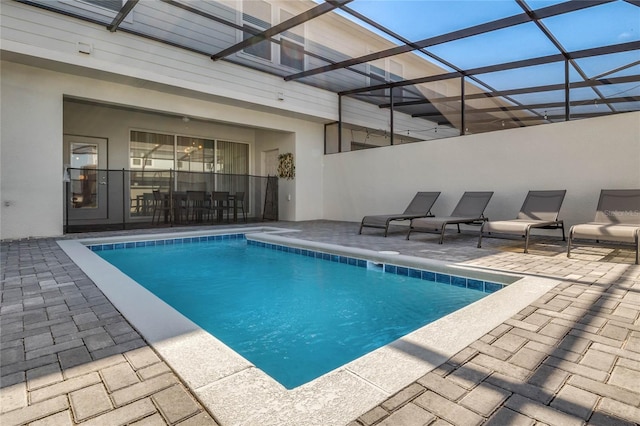 view of swimming pool with glass enclosure and a patio area