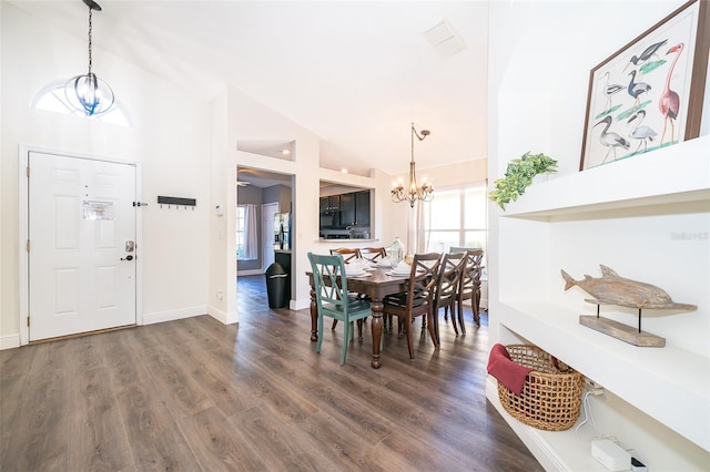 dining space featuring high vaulted ceiling, dark hardwood / wood-style floors, and a notable chandelier