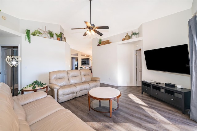 living room with dark hardwood / wood-style flooring, vaulted ceiling, and ceiling fan