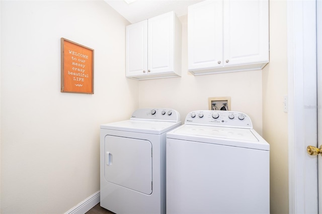 washroom with washer and dryer and cabinets