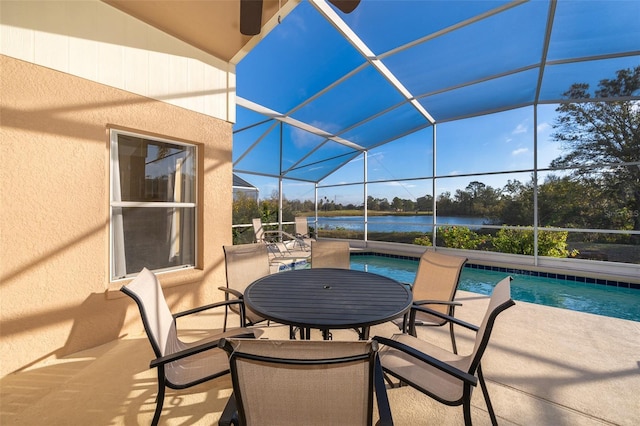 view of patio with glass enclosure and a water view