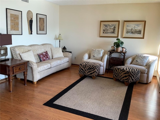 living area with visible vents and wood finished floors