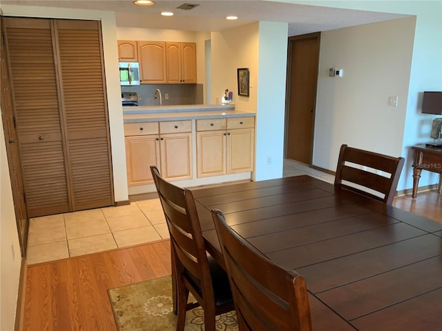 dining area with recessed lighting and light wood finished floors