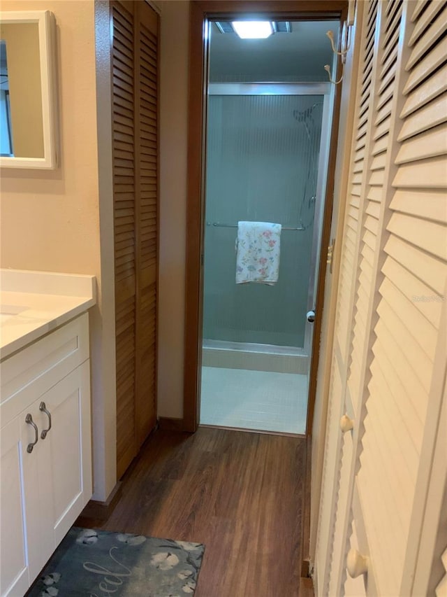 bathroom with a shower, a closet, vanity, and wood finished floors