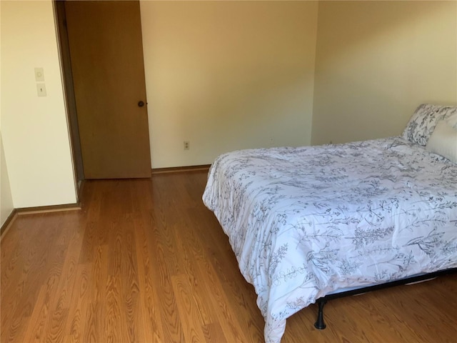 bedroom with baseboards and wood finished floors