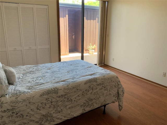 bedroom with light wood-type flooring, baseboards, and a closet