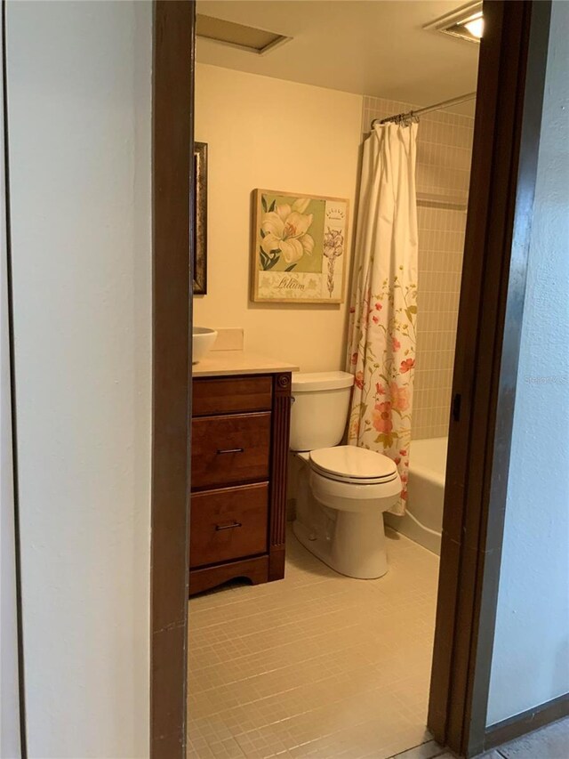 bathroom with vanity, shower / bath combination with curtain, and toilet