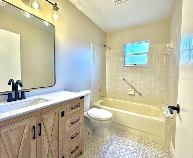 full bathroom featuring tile patterned floors, vanity, toilet, and tiled shower / bath