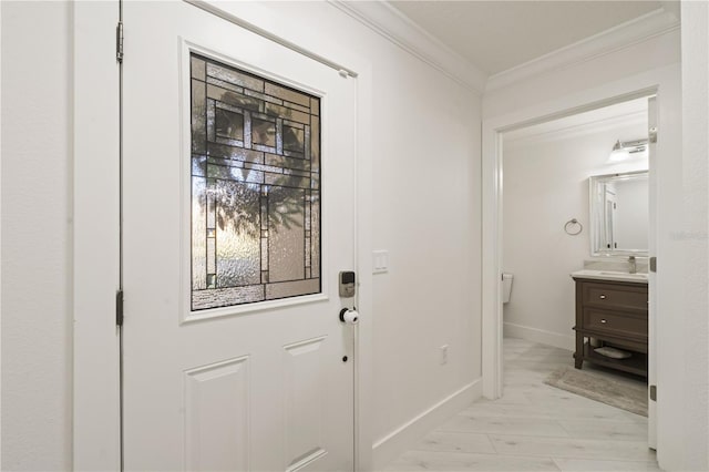 doorway featuring light wood-type flooring, ornamental molding, and sink