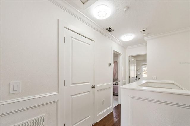 laundry room with dark hardwood / wood-style flooring and ornamental molding