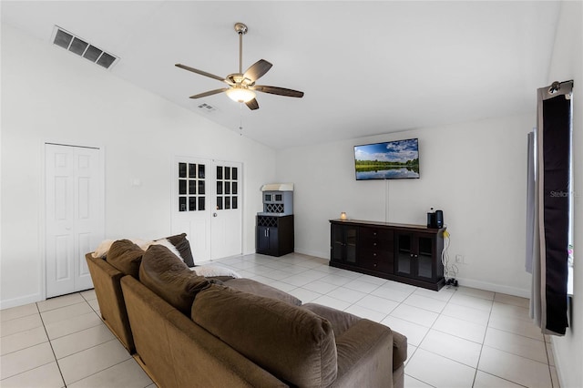 tiled living room with ceiling fan, high vaulted ceiling, and french doors