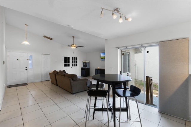 dining space featuring ceiling fan, light tile patterned flooring, and lofted ceiling