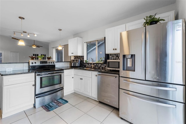 kitchen featuring ceiling fan, hanging light fixtures, white cabinets, and stainless steel appliances