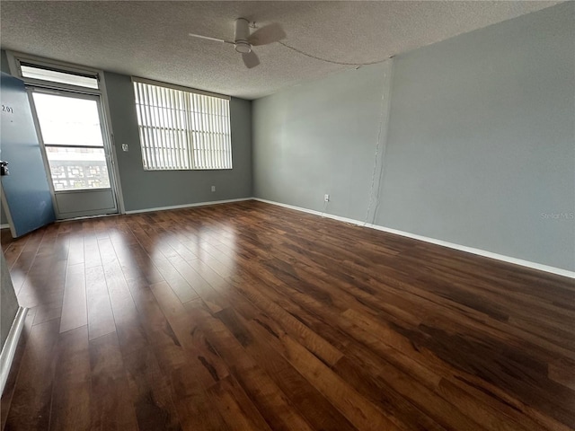 spare room featuring dark hardwood / wood-style flooring, a textured ceiling, and ceiling fan