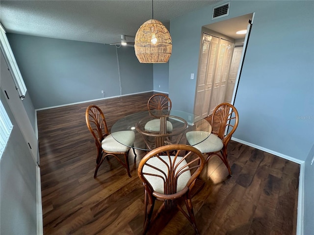 dining area featuring dark hardwood / wood-style floors and a textured ceiling