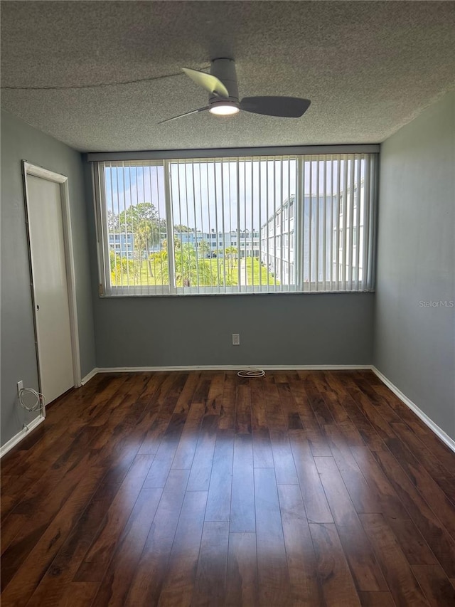 spare room with ceiling fan, dark hardwood / wood-style flooring, and a textured ceiling