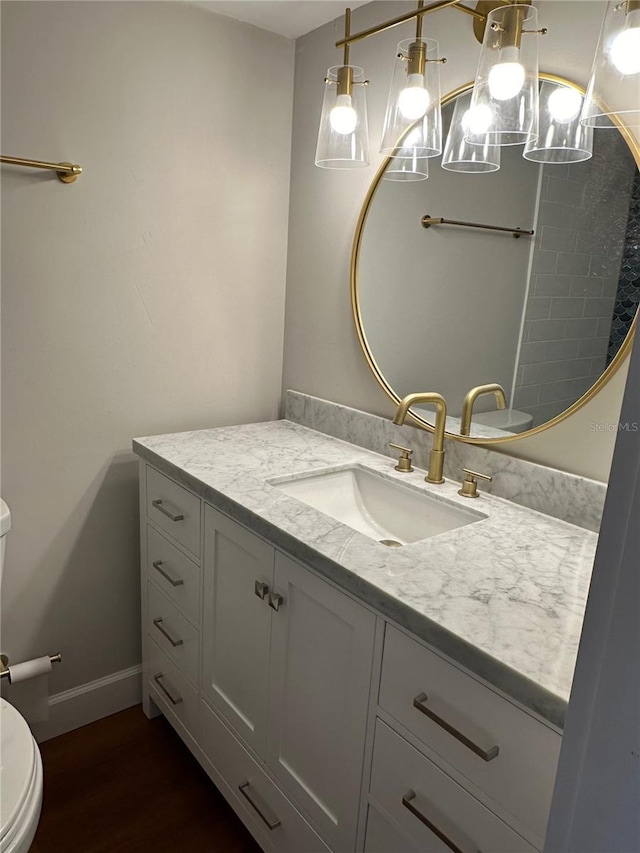 bathroom with hardwood / wood-style floors, vanity, and toilet