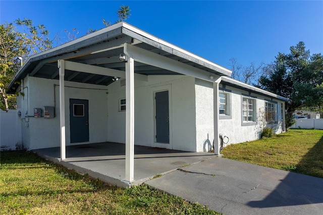 back of property featuring a yard and a carport