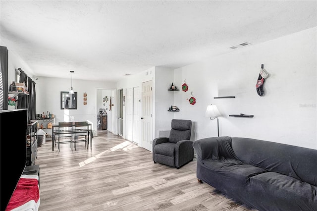 living room with light hardwood / wood-style flooring and a textured ceiling