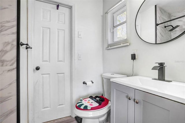 bathroom with hardwood / wood-style flooring, vanity, toilet, and walk in shower