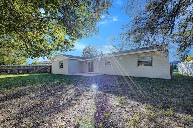 rear view of house with a lawn and a patio