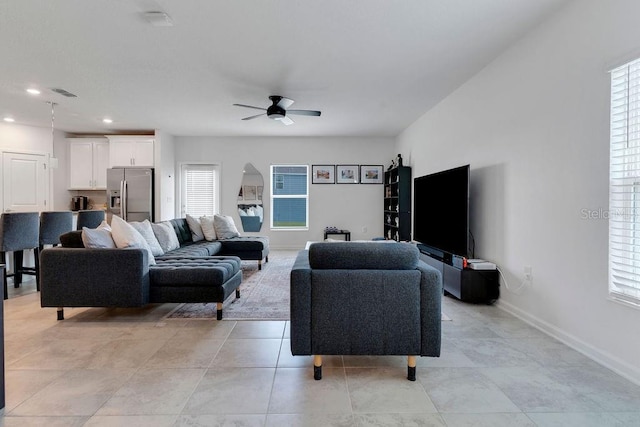 living room featuring ceiling fan and a healthy amount of sunlight