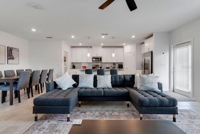 tiled living room featuring ceiling fan