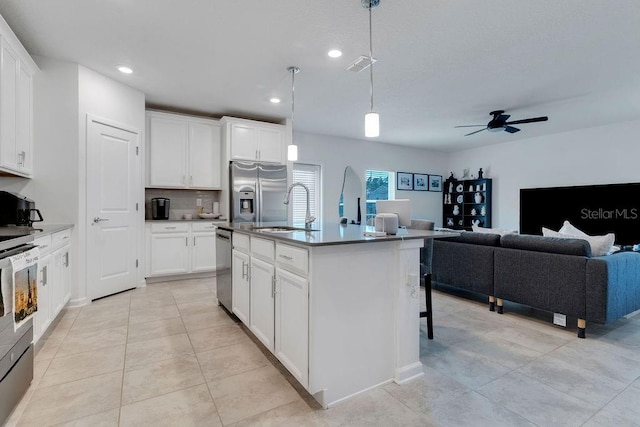 kitchen with white cabinetry, sink, decorative light fixtures, a center island with sink, and appliances with stainless steel finishes