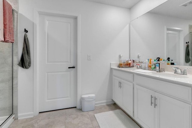 bathroom with tile patterned flooring, vanity, and walk in shower