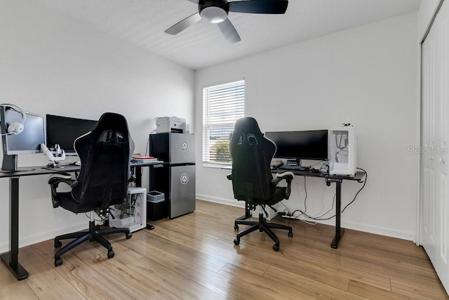 office area with light wood-type flooring and ceiling fan