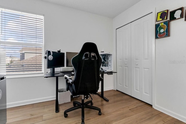 home office with light hardwood / wood-style flooring