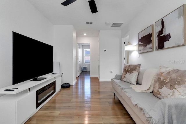 living room with light hardwood / wood-style flooring and ceiling fan