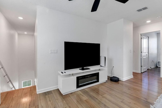 living room featuring ceiling fan and hardwood / wood-style flooring