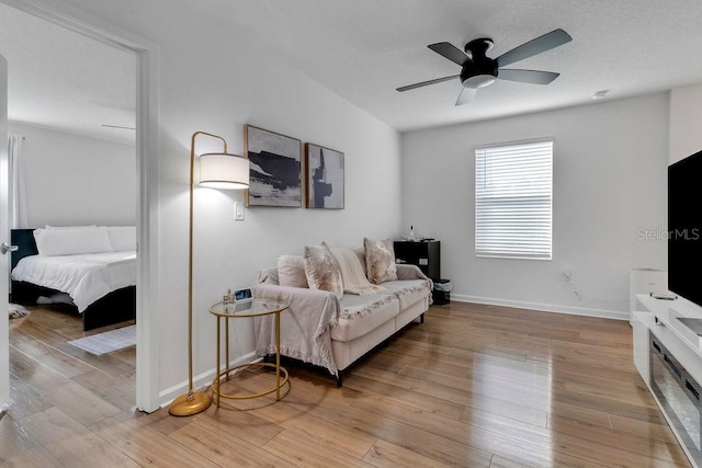 living room with ceiling fan and light wood-type flooring