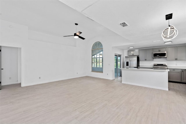 kitchen with light hardwood / wood-style floors, stainless steel appliances, a center island, gray cabinets, and hanging light fixtures