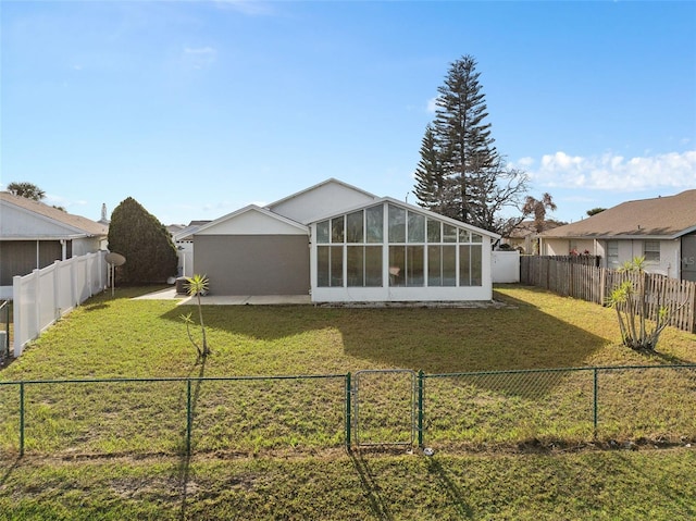 back of property with a lawn and a sunroom