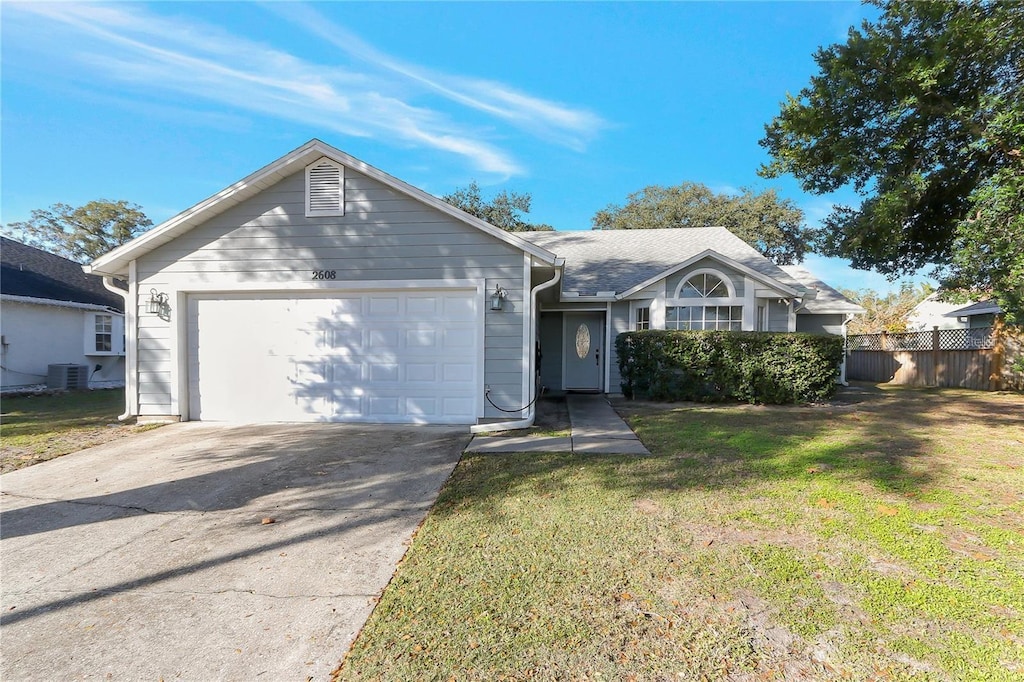 single story home featuring a front lawn, a garage, and central AC