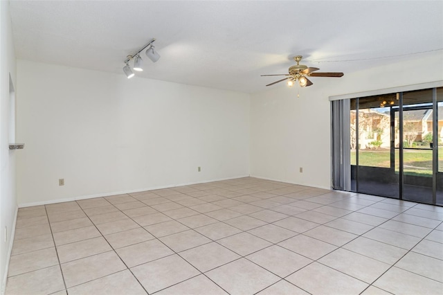 empty room with ceiling fan, light tile patterned floors, and track lighting