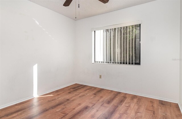 unfurnished room with hardwood / wood-style floors, ceiling fan, and a textured ceiling