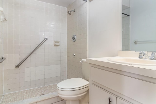 bathroom with vanity, toilet, and a tile shower