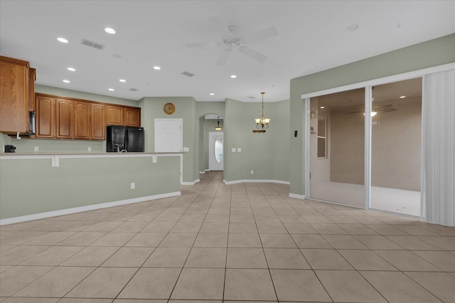 kitchen featuring ceiling fan with notable chandelier, black fridge, light tile patterned floors, and decorative light fixtures