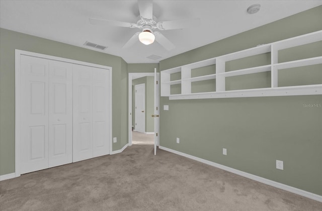 unfurnished bedroom with ceiling fan, a closet, and light colored carpet