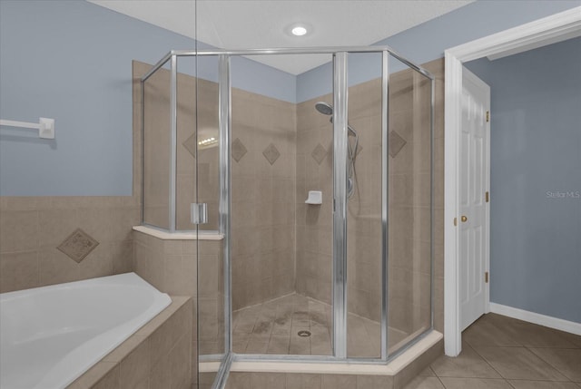 bathroom featuring tile patterned flooring and separate shower and tub