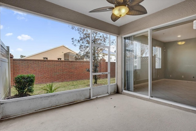 unfurnished sunroom with ceiling fan