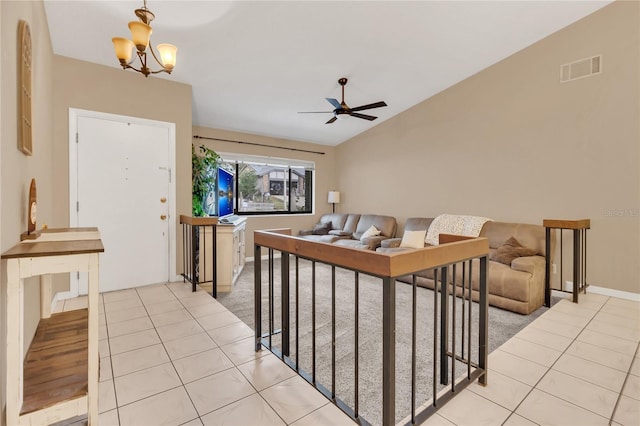 living room with ceiling fan with notable chandelier, light tile patterned floors, and vaulted ceiling