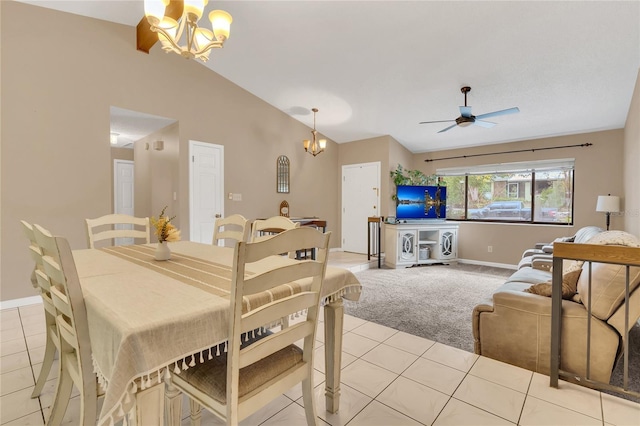 tiled dining space with ceiling fan with notable chandelier and lofted ceiling